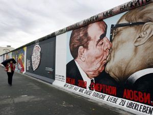 Eine Passanten betrachtet am Freitag (06.11.2009) an der frisch restaurierten East Side Gallery in Berlin das Gemälde "Bruderkuss zwischen Honecker und Breschnew" von Dimitrij Vrubel. Grund für den Erfolg der Gallery seien die unterschiedlichen und internationalen Sichtweisen der Künstler auf den Mauerfall vor 20 Jahren. Monatelang war die im Lauf der Jahre blass gewordene Open-Air-Galerie restauriert worden. 94 der 118 Künstler, die im Jahr nach dem Mauerfall 1990 ihre Bilder an die Mauer gemalt hatten, kamen dafür wieder nach Berlin. Foto: Wolfgang Kumm dpa/lbn +++(c) dpa - Bildfunk+++